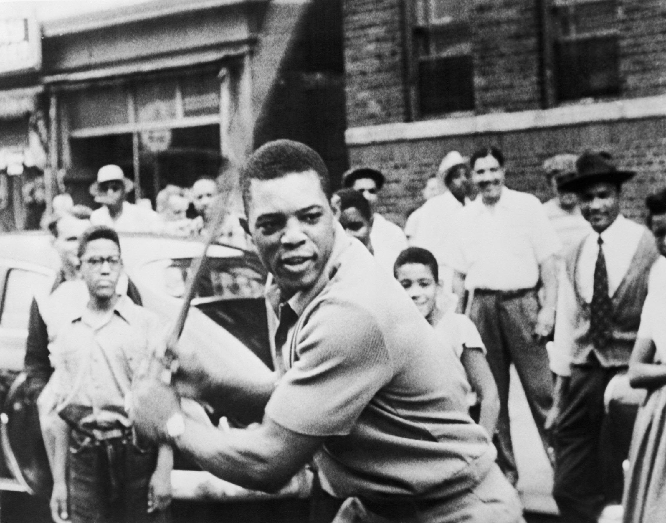 Mays plays stick ball with kids in New York's Harlem neighborhood in 1954.