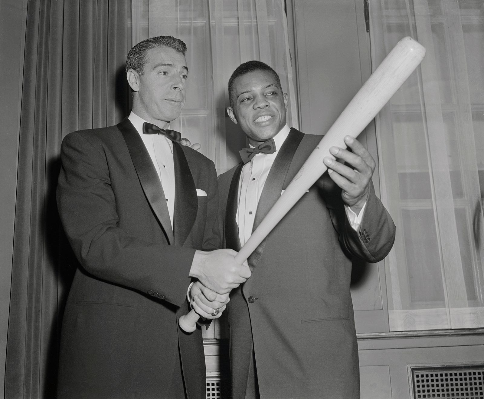 Mays gets batting tips from Joe DiMiaggio, at the 32nd annual dinner of the Baseball Writers at the Waldorf Astoria in 1955.