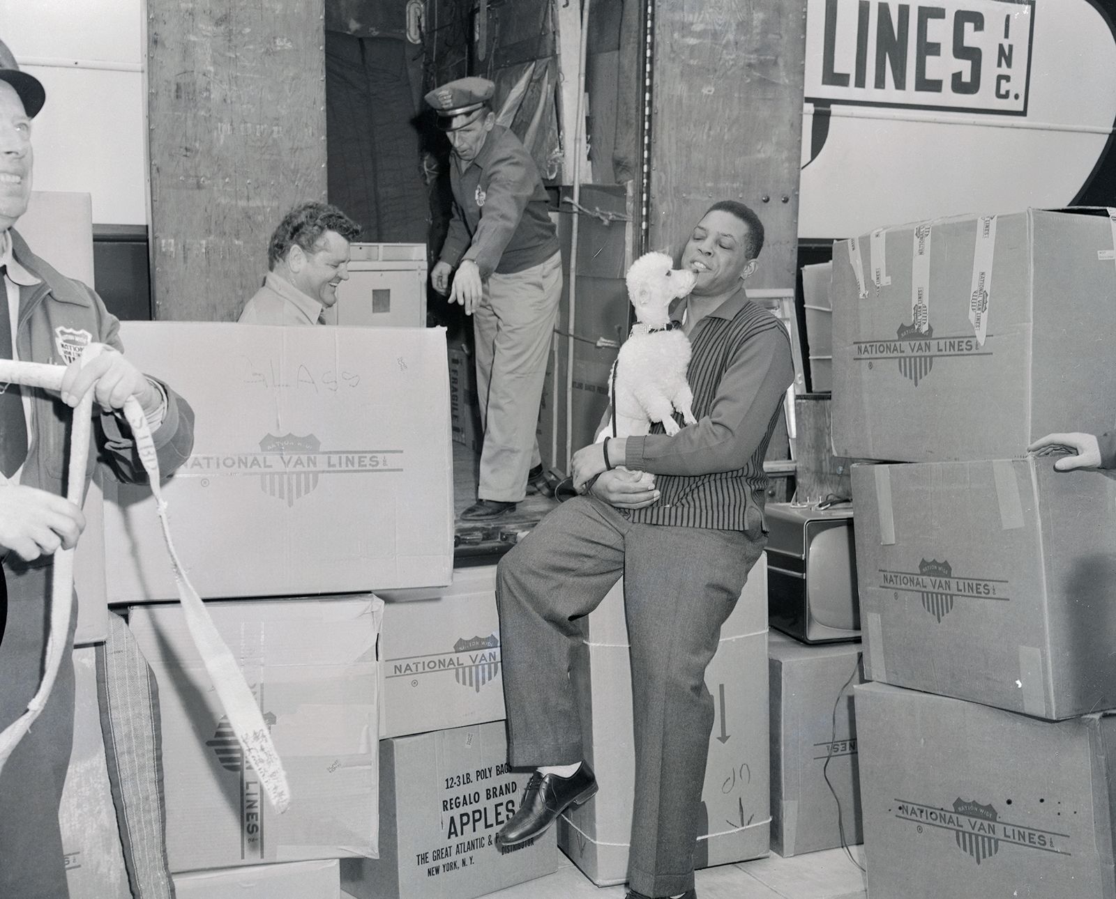 Mays gets a kiss from his dog Pepe while moving into their new San Francisco home on January 15, 1958.