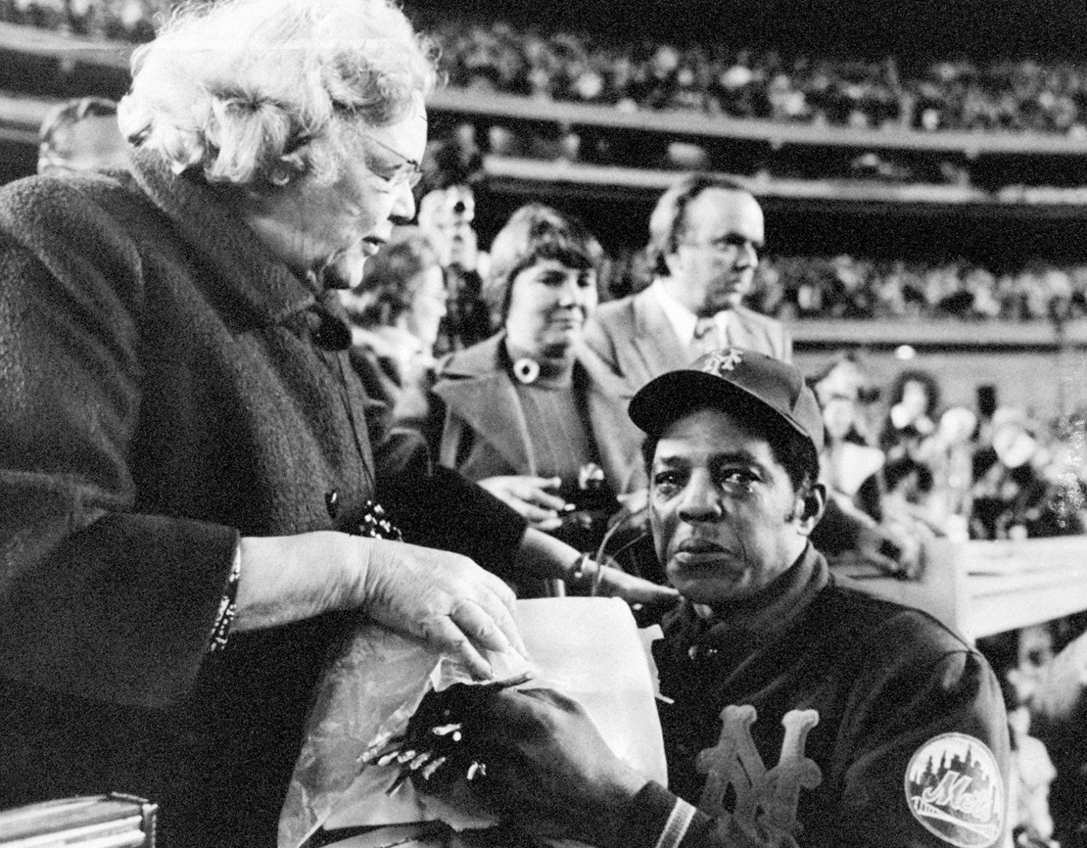 Mays cries after he is bid farewell by New York Mets' owner Joan Whitney Payson during a ceremony for Mays at Shea Stadium in New York City on September 26, 1973. After one year with the Mets, Mays retired from professional baseball. 