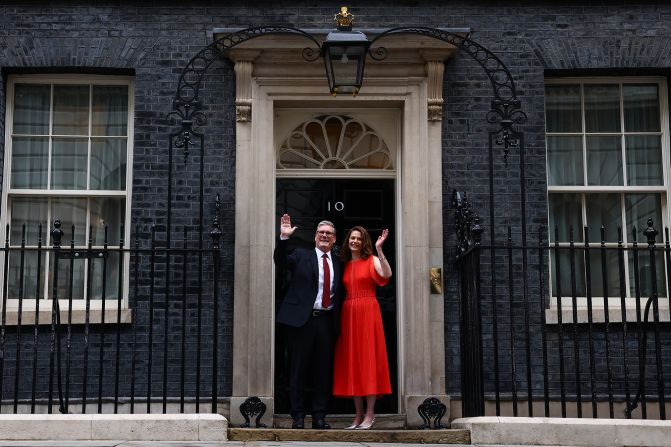 The Starmers wave from the steps of No. 10 Downing Street.