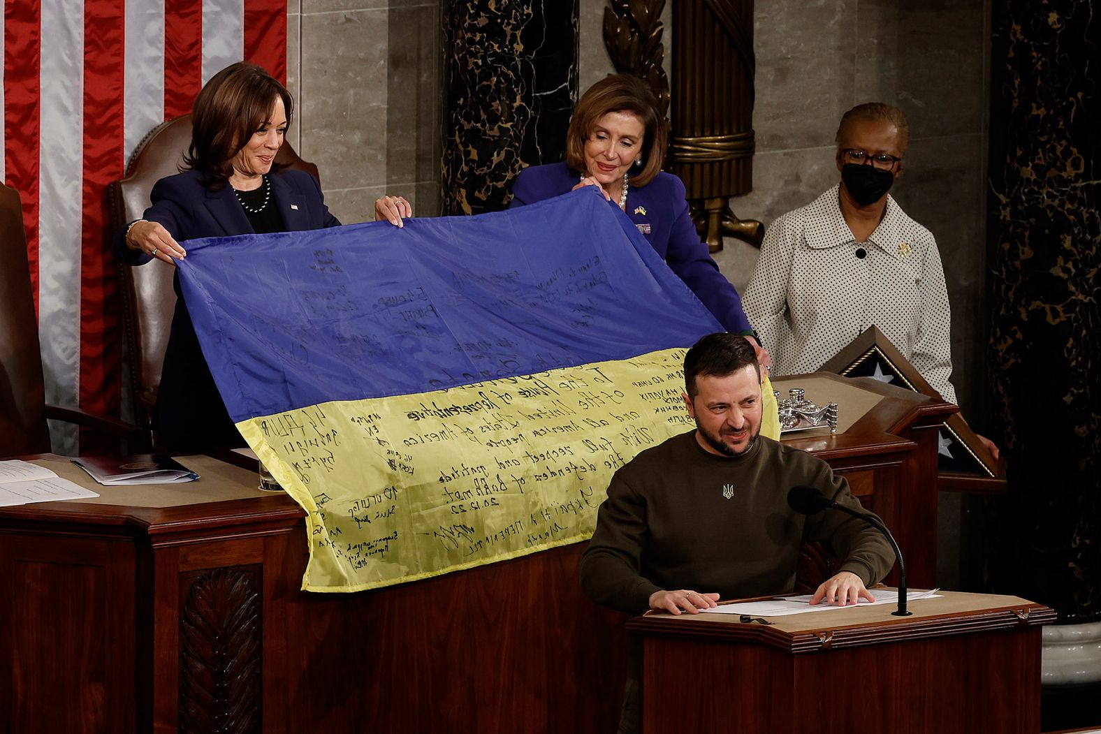 Ukrainian President Volodymyr Zelensky <a  target="_blank">addresses Congress at the US Capitol</a> in December 2022 as Harris and House Speaker Nancy Pelosi hold up a Ukrainian national flag signed by troops from the besieged area of Bakhmut.