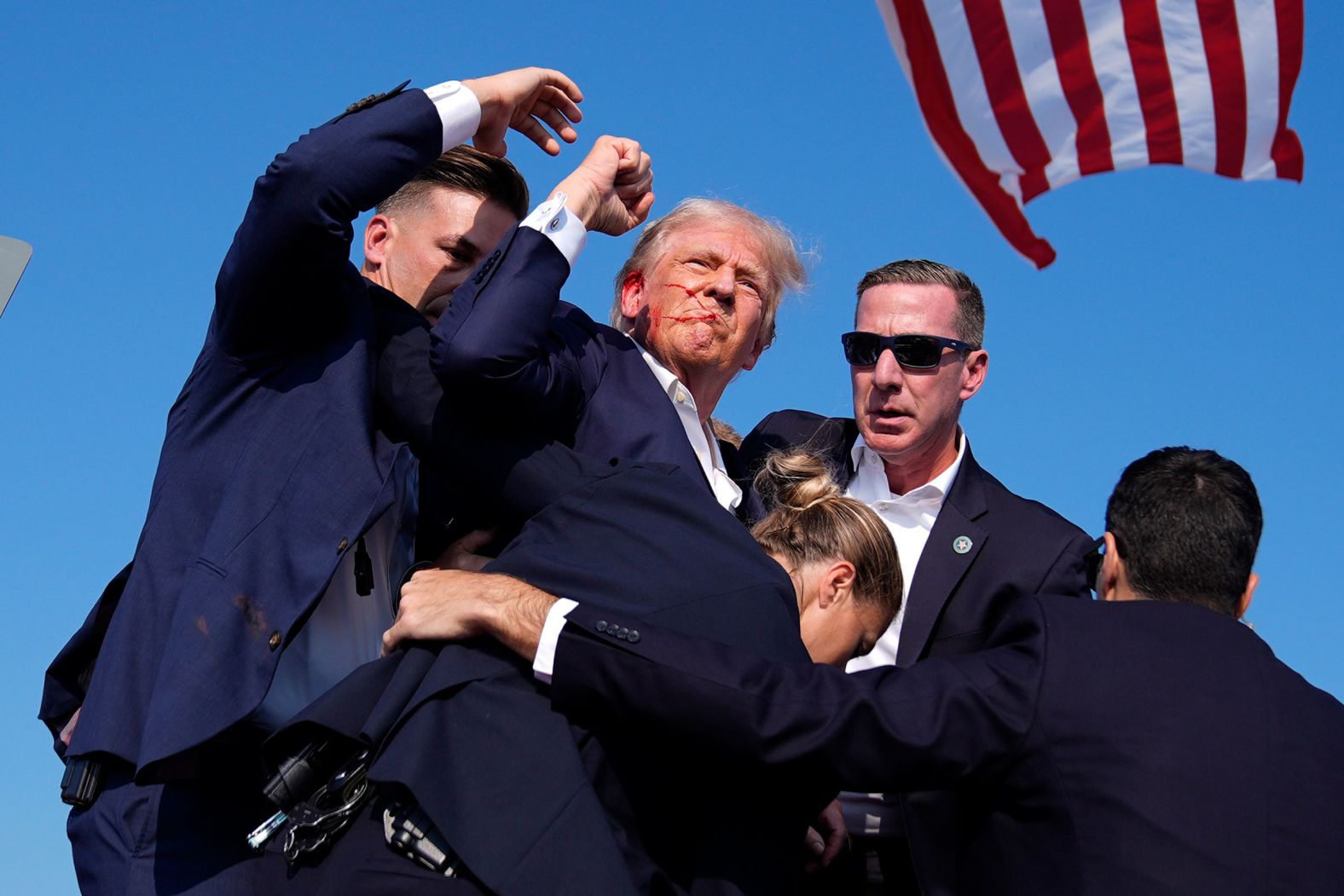 Trump, with blood on his face, raises his fist to the crowd as he is surrounded by Secret Service agents at a campaign rally in Butler, Pennsylvania, in July 2024. <a href="https://www.cnn.com/2024/07/13/politics/trump-injured-pennsylvania-rally/index.html" target="_blank">Trump was injured</a> in a shooting that the FBI said was an assassination attempt.