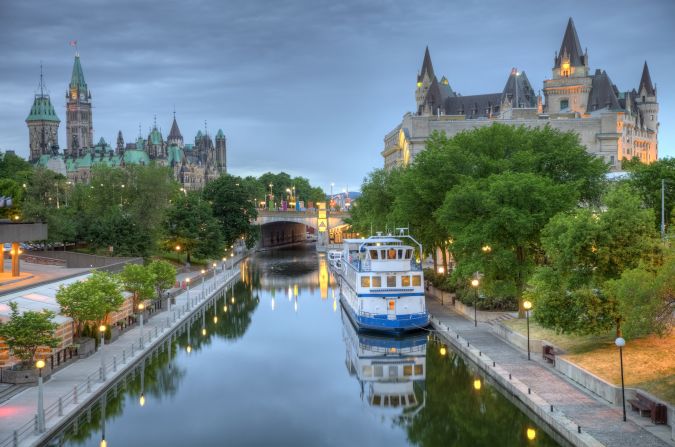 Parliament Hill along the banks of the Rideau Canal in Ottawa Ontario. Parliament Hill is home to Canada's federal government and is the centrepiece of Ottawa's downtown landscape. Ottawa is known for is high-tech business sector, vast array of museums and high standard of living.