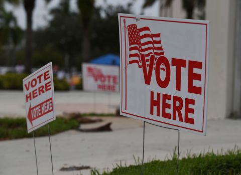 Signs are seen outside of a polling location in Coral Springs, Florida, on October 19.