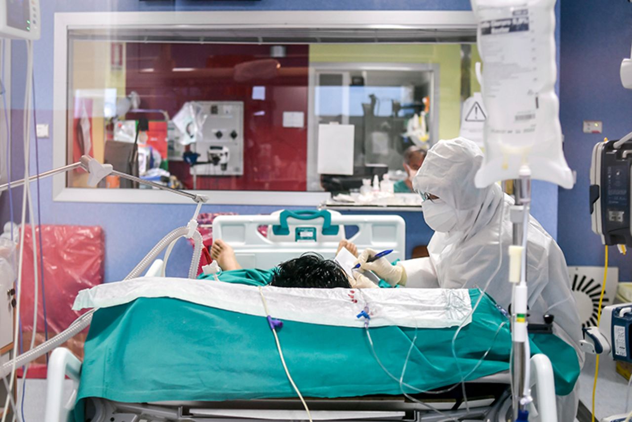 A medical staffer writes a note to communicate with a patient he is tending to, in the ICU of the Bassini Hospital, in Cinisello Balsamo, near Milan, Italy, Tuesday, April 14. 