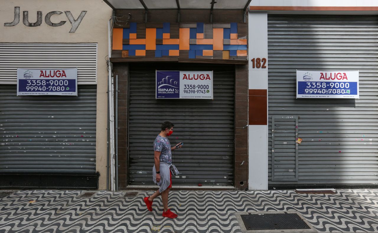 A man walks in front of a shuttered shop on June 29 in Sao Paulo, Brazil. 