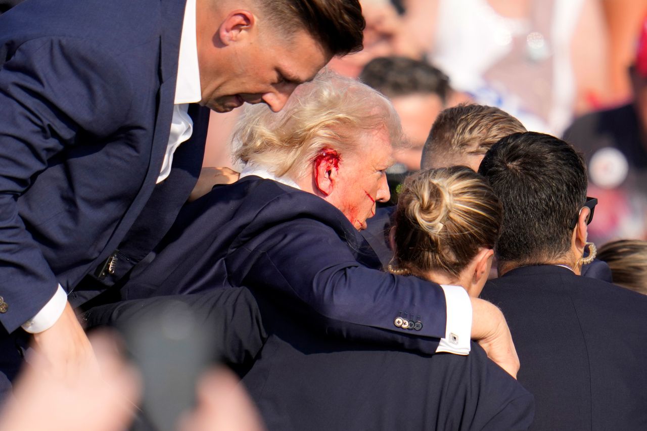 Blood is seen on Trump's right ear as he is helped off the stage. 