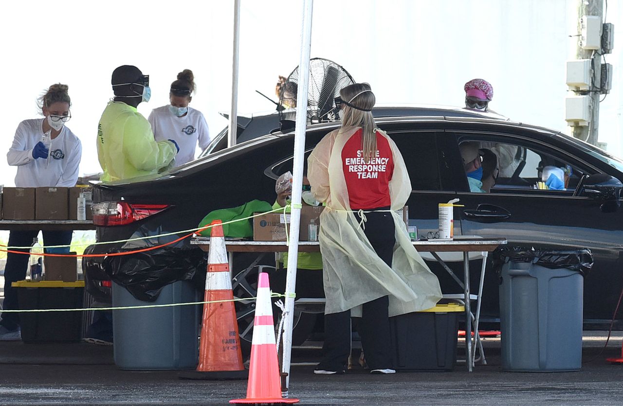 Health care workers perform Covid-19 testing at a drive-through site at Eastern Florida State College on October 9, in Palm Bay, Florida.