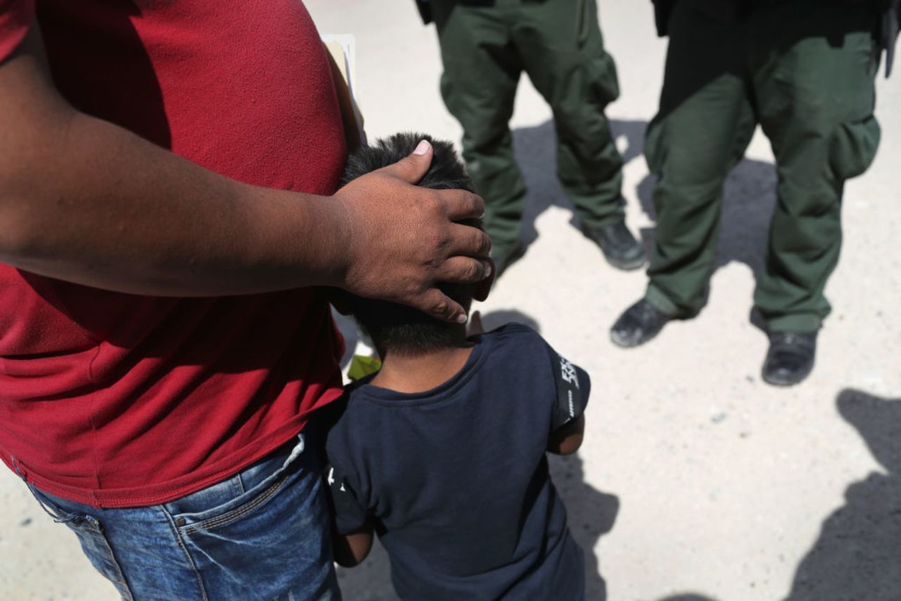 US Border Patrol agents take a father and son from Honduras into custody near the US-Mexico border on June 12, 2018 near Mission, Texas.