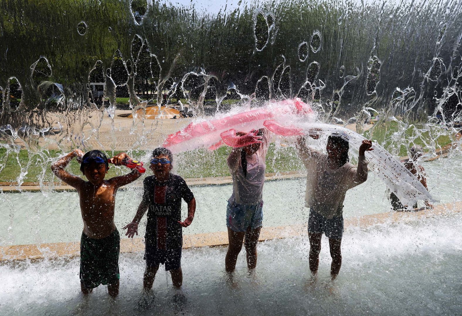 Children play in a fountain at a park in Tokyo, Japan, on Monday, August 4.