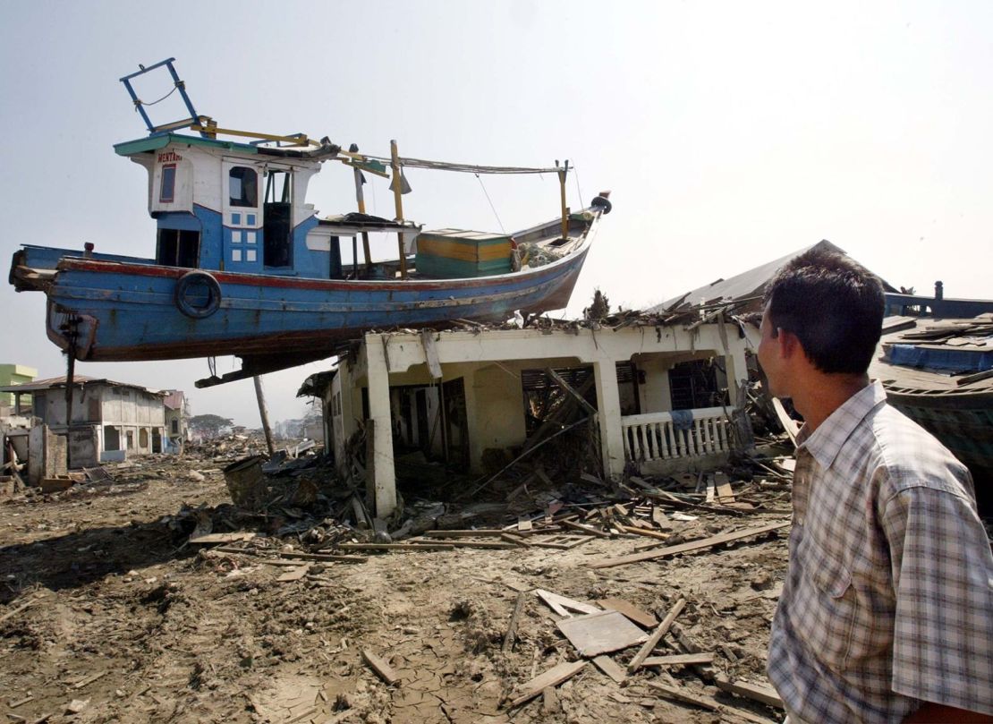 Un hombre examina un barco situado en lo alto de una casa en Banda Aceh.