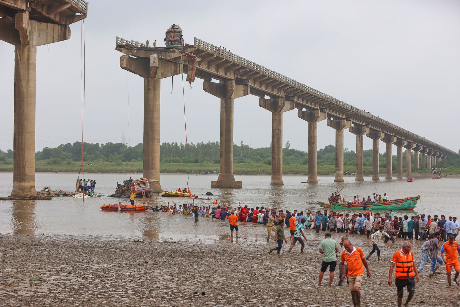 Rescuers and locals look for survivors after a <a href="index.php?page=&url=https%3A%2F%2Fwww.cnn.com%2F2025%2F07%2F09%2Fasia%2Fgujarat-bridge-collapse-intl">bridge collapsed</a> in Mujpur, India, on Wednesday, July 9. At least nine people were killed after several vehicles fell into the river, news agency Press Trust of India reported while quoting police officials.