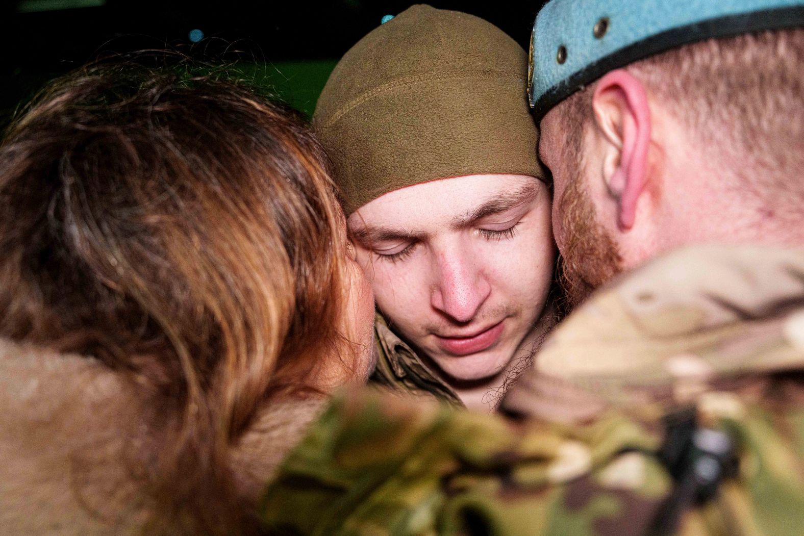 A Ukrainian serviceman is hugged on Monday, December 30, after he returned from captivity following a prisoner-of-war swap between Ukraine and Russia.