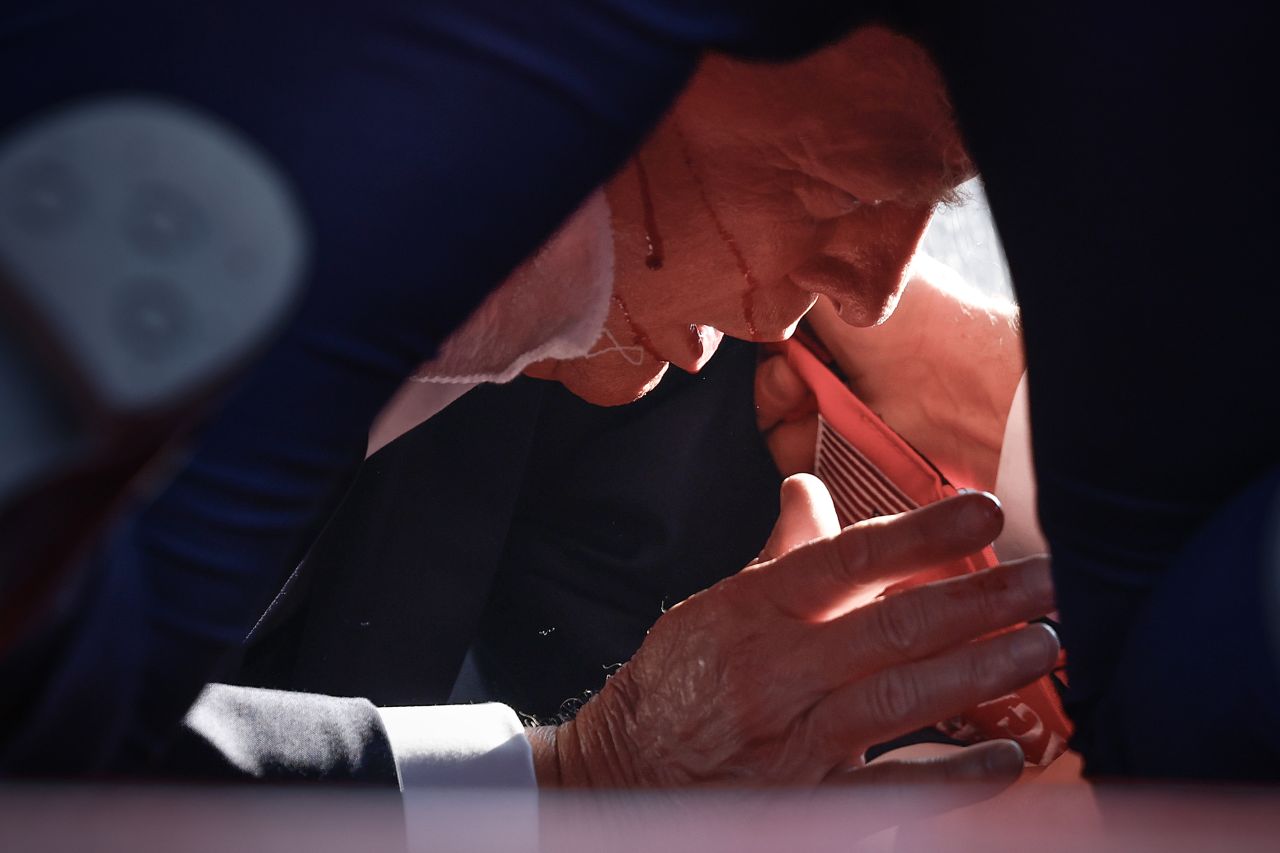 Donald Trump is shown covered by US Secret Service agents after an incident during a rally in Butler, Pennsylvania, on July 13.