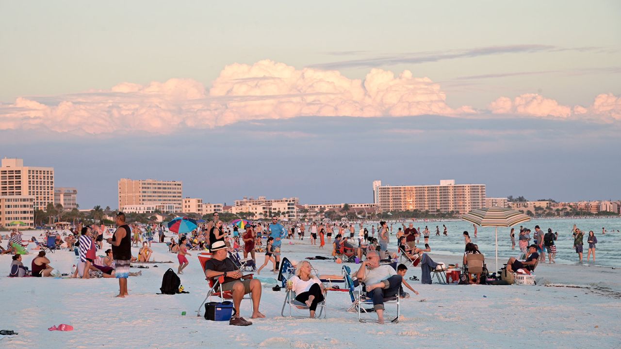 Visitors enjoy Siesta Key Beach as the sun sets over the Gulf of Mexico in Sarasota, Florida on June 17. 