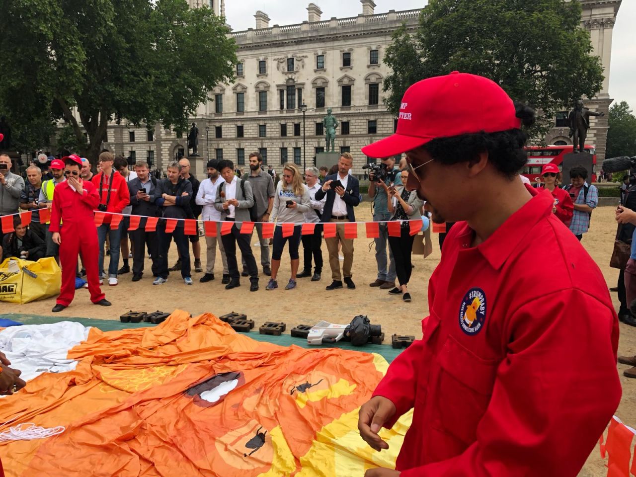 Dave Fuller of London prepares the balloon ahead of its launch. His hat says “trump babysitter."Fuller says: “Trump acts like a big baby, so we’ve made a big baby of trump”