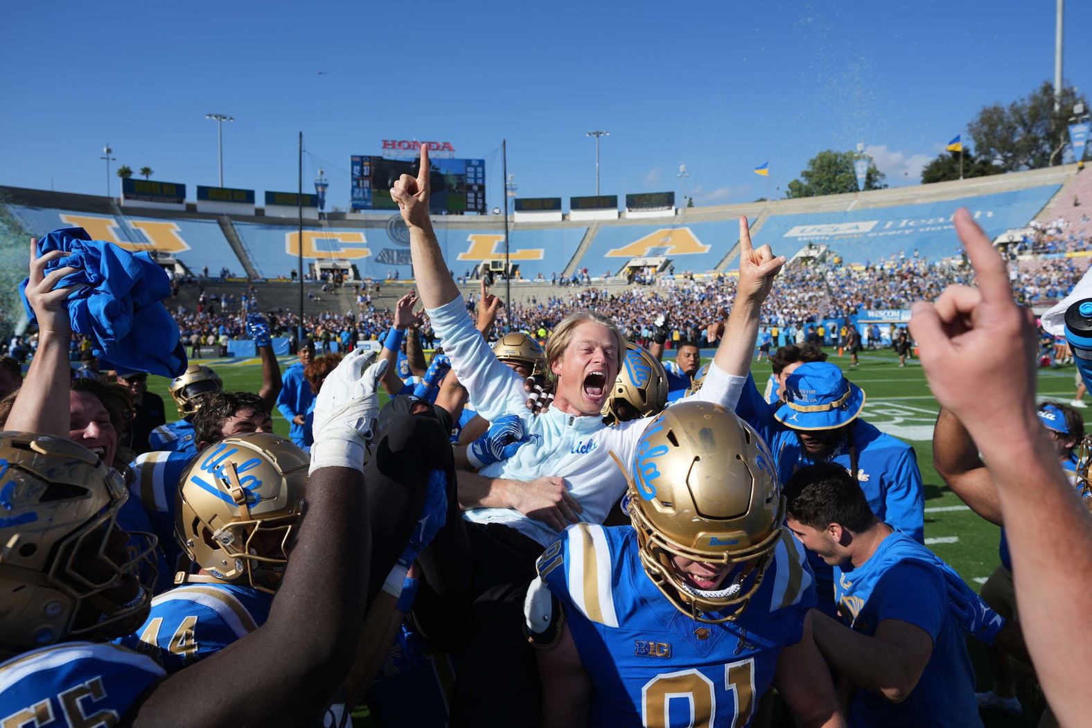 Jerry Neuheisel, UCLA’s interim offensive coordinator, is lifted by players after their <a href="index.php?page=&url=https%3A%2F%2Fbleacherreport.com%2Farticles%2F25257125-no-7-psu-upset-nico-iamaleava-winless-ucla-fans-put-james-franklin-hot-seat" target="_blank">42-37 upset win over Penn State</a> on Saturday, October 4. It was Neuheisel’s first game calling plays for the Bruins, who came into the game 0-4 and fired head coach DeShaun Foster last month. It was the first time since 1985 than an 0-4 team had beaten a top-10 opponent.