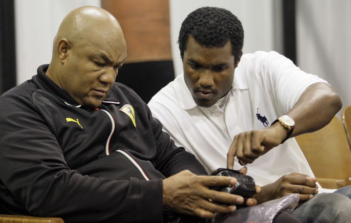 Foreman looks at a training video alongside his son George Foreman III in 2009. The younger Foreman was set to make his professional boxing debut later that week.