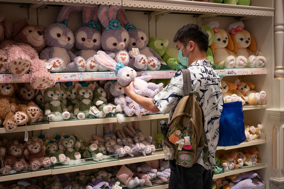 A man looks at a "Duffy and Friends" stuffed toy.