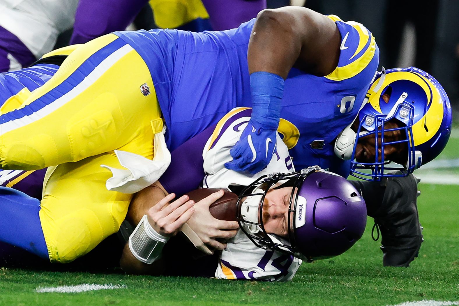 Minnesota Vikings quarterback Sam Darnold, bottom, is sacked by Los Angeles Rams defensive tackle Kobie Turner during an NFL playoff game in Glendale, Arizona, on Monday, January 13. <a href="index.php?page=&url=https%3A%2F%2Fwww.cnn.com%2F2025%2F01%2F13%2Fsport%2Fnfl-rams-defeat-vikings-in-arizona-spt%2Findex.html">The Rams sacked Darnold nine times</a> — tying an NFL playoff record — as they won 27-9.