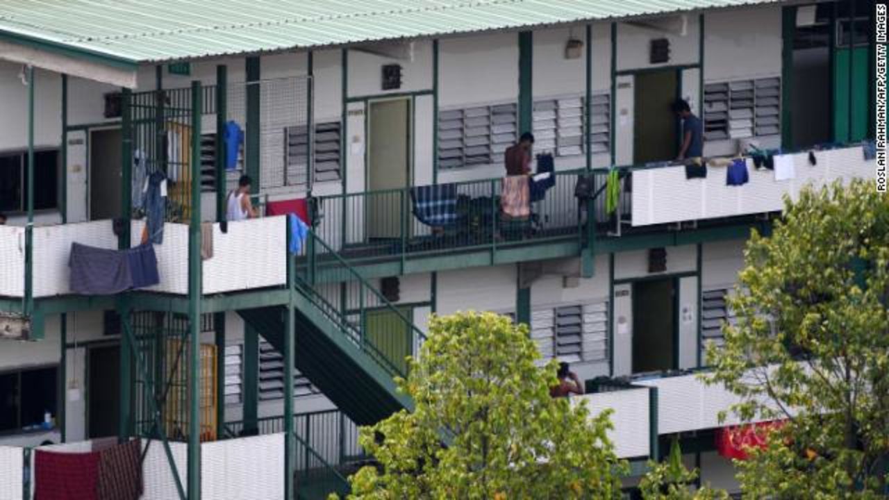 Men stand along a balcony of a dormitory used by foreign workers in Singapore on April 17.