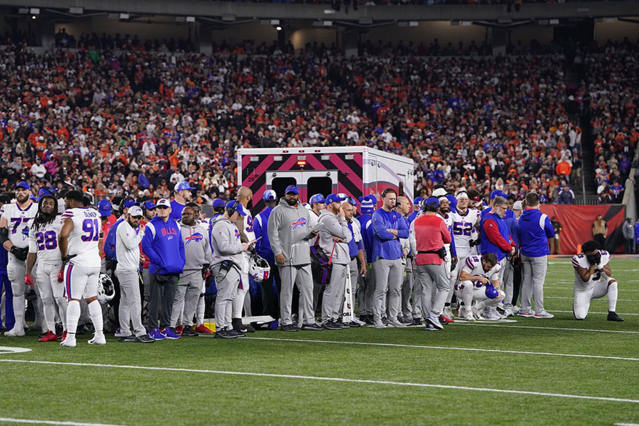 Players look on as an ambulance arrives on the field. 