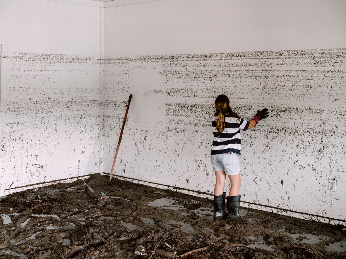 The daughter of the owner of Vintage Hair Co. looks at water lines on the wall of the salon, which was destroyed by flooding in Ingram, Texas, on Saturday, July 5.
