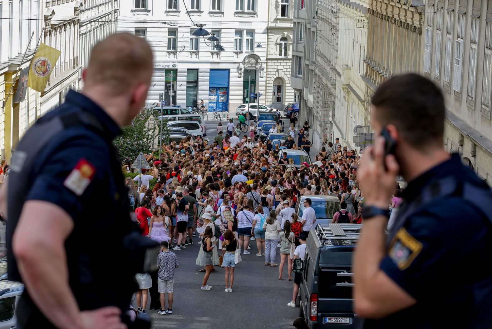 Police officers watch Taylor Swift fans gather in the center of Vienna, Austria, on Thursday, August 8. <a href="index.php?page=&url=https%3A%2F%2Fwww.cnn.com%2F2024%2F08%2F07%2Fentertainment%2Ftaylor-swift-concert-vienna-arrests%2Findex.html">Organizers canceled three Swift concerts in Austria</a> after authorities said they foiled a terror attack planned for the Vienna leg of her blockbuster tour.