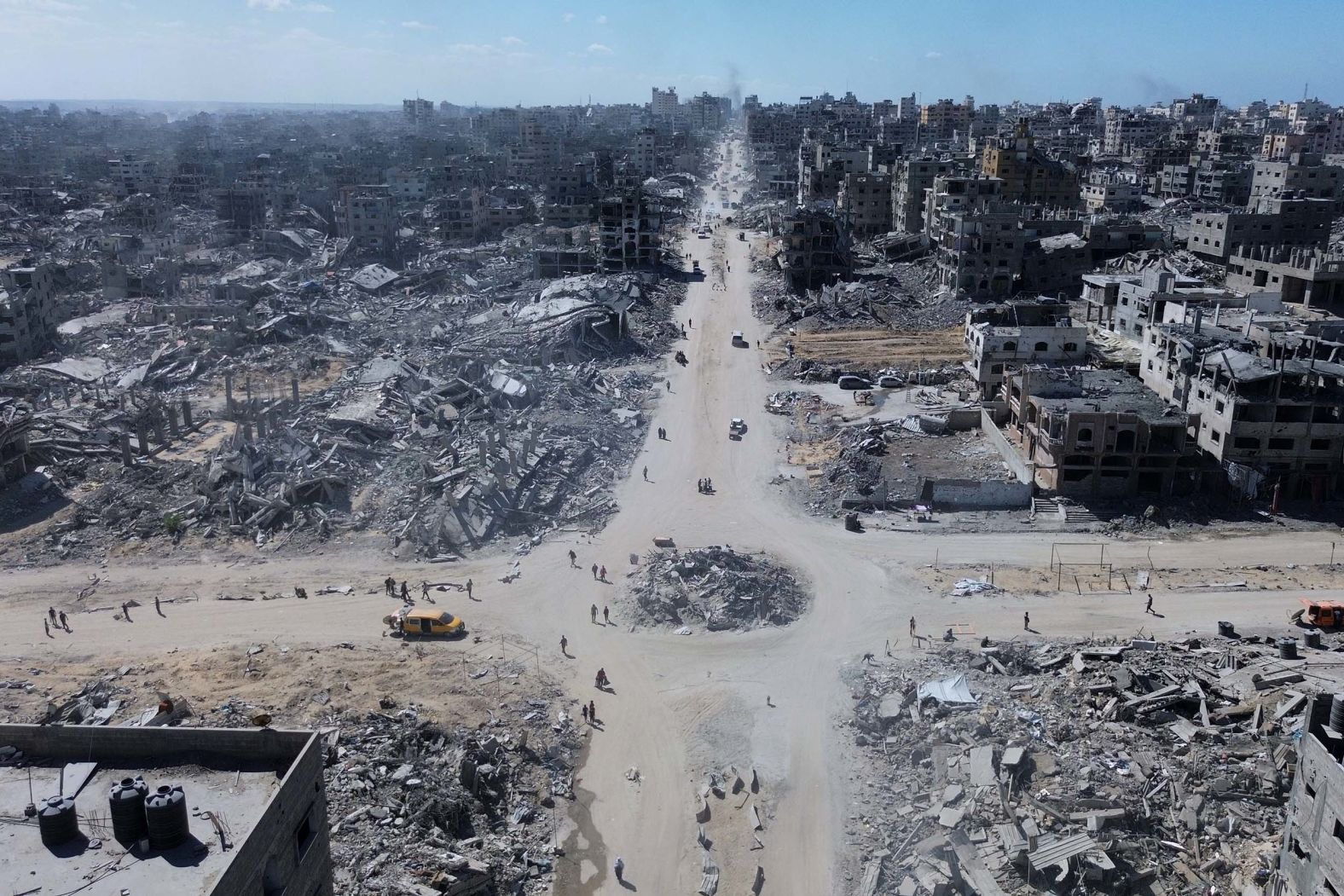 People walk at an intersection in Gaza City on Wednesday, October 15. Many of the buildings have been destroyed by Israeli bombardments over the last two years.