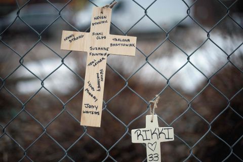 Crosses bearing the names of the shooting victims hang from a fence.