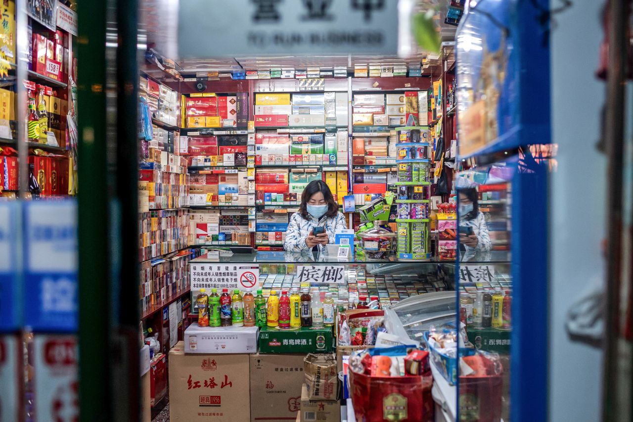 A?vendor wearing a protective face mask waits for customers at a shop in Beijing.