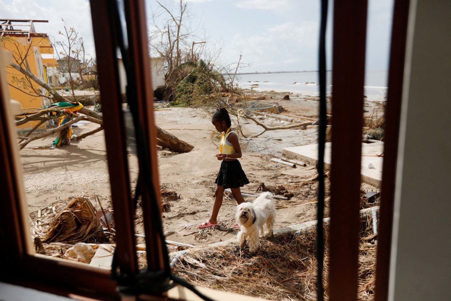 A child and a dog walk in Black River, Jamaica, on Thursday, October 30, two days after Hurricane Melissa made landfall.