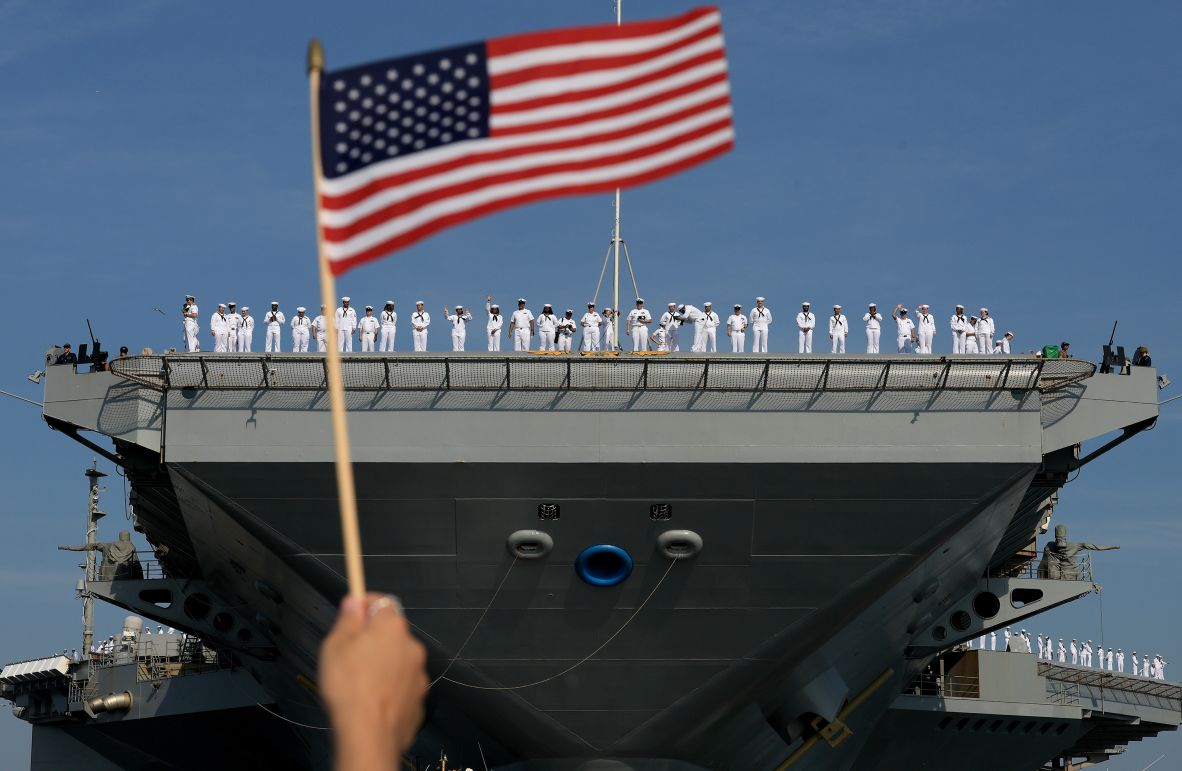 US sailors stand on the deck of the USS Gerald R. Ford as they wait for the aircraft carrier to leave Norfolk, Virginia, on Tuesday, June 24. They were leaving for a scheduled deployment.