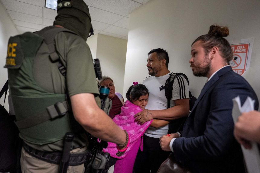 A migrant is embraced by his daughter as he is informed he is going to be detained by federal immigration officers at immigration court in Manhattan on July 31.