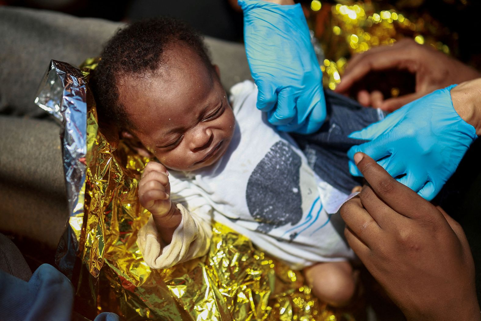 A young migrant is cared for by Dr. Isabel Zamarron on board the Open Arms rescue boat Astral in the central Mediterranean Sea on Saturday, August 10.