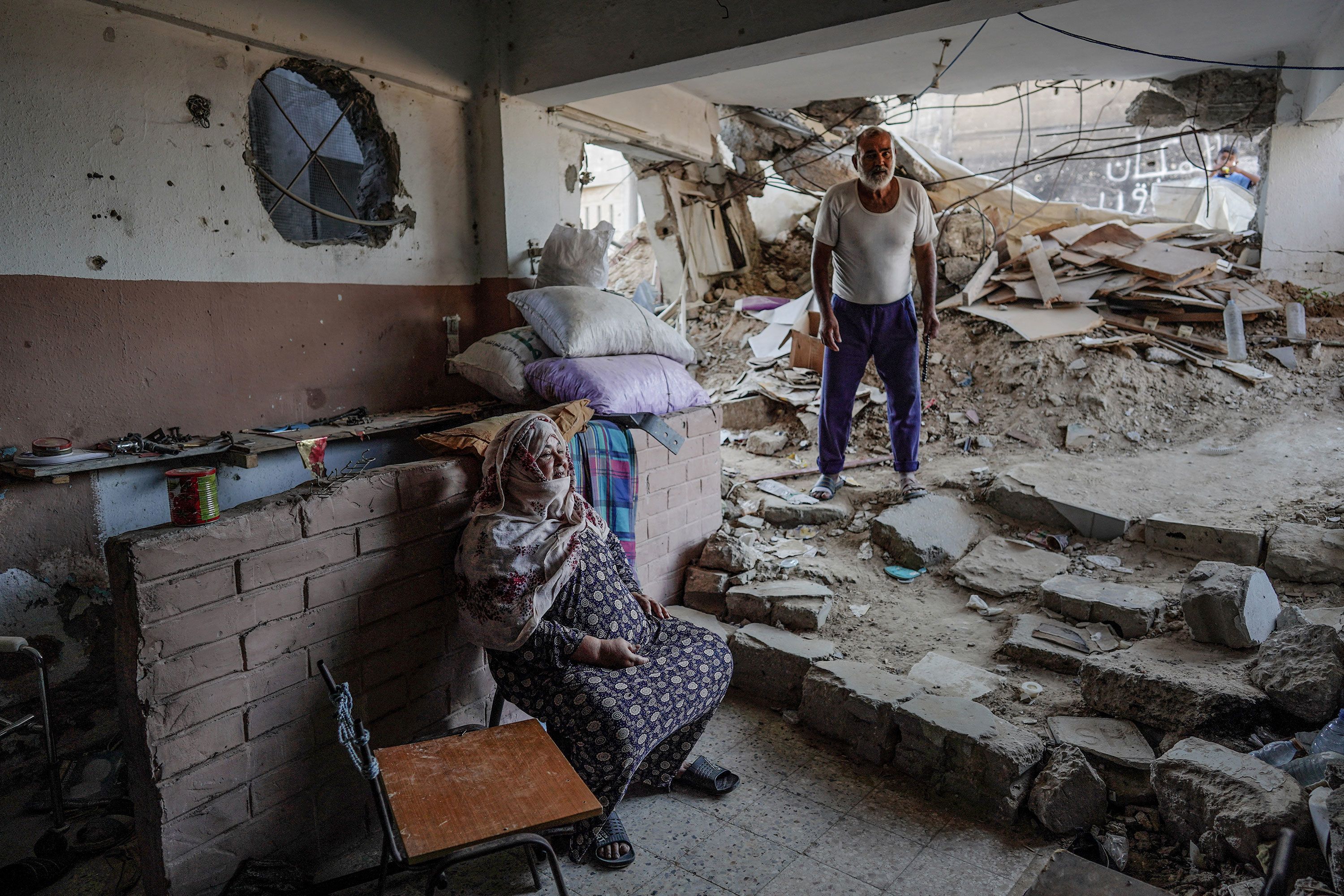 Hussein Abu Assi, right, stands inside his house in Bani Suheila, Gaza, on Wednesday, July 17. It was heavily damaged by Israeli bombardment amid Israel’s war against the Palestinian militant group Hamas.