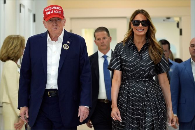 Trump and his wife, Melania, walk up to the press after voting in Palm Beach, Florida, on Tuesday.