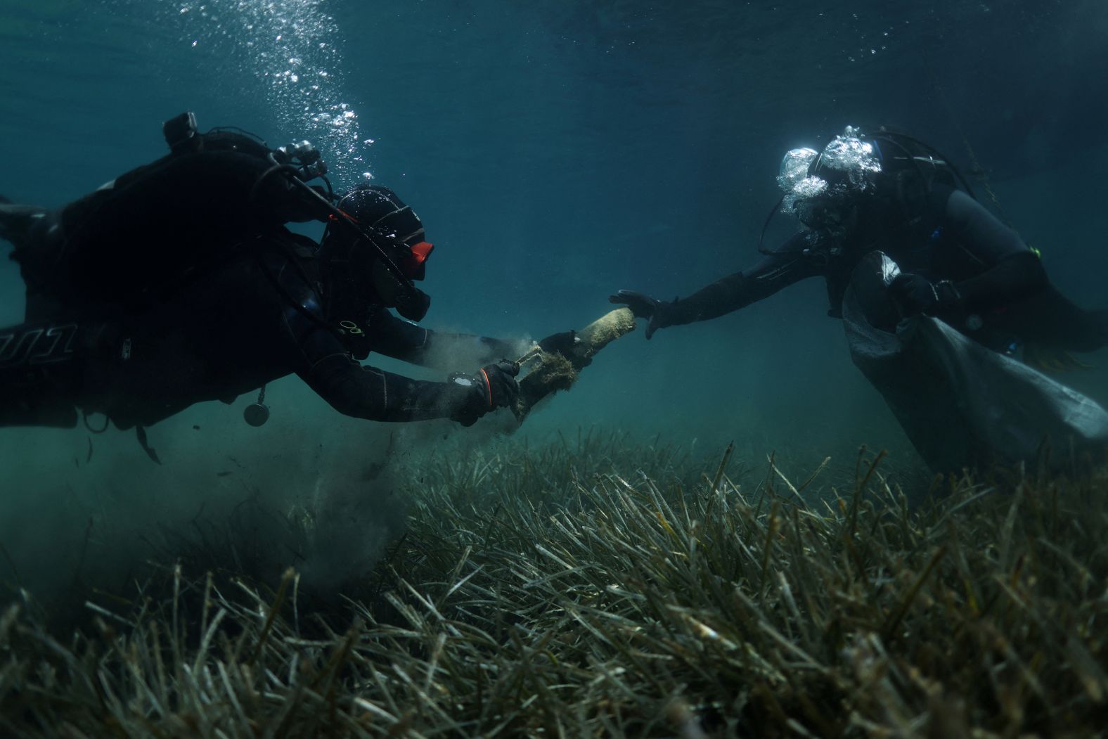 Volunteer divers from the environmental group Aegean Rebreath gather waste from the bottom of the seabed at the port of Votsi, on the Greek island of Alonissos, on Saturday, May 24.