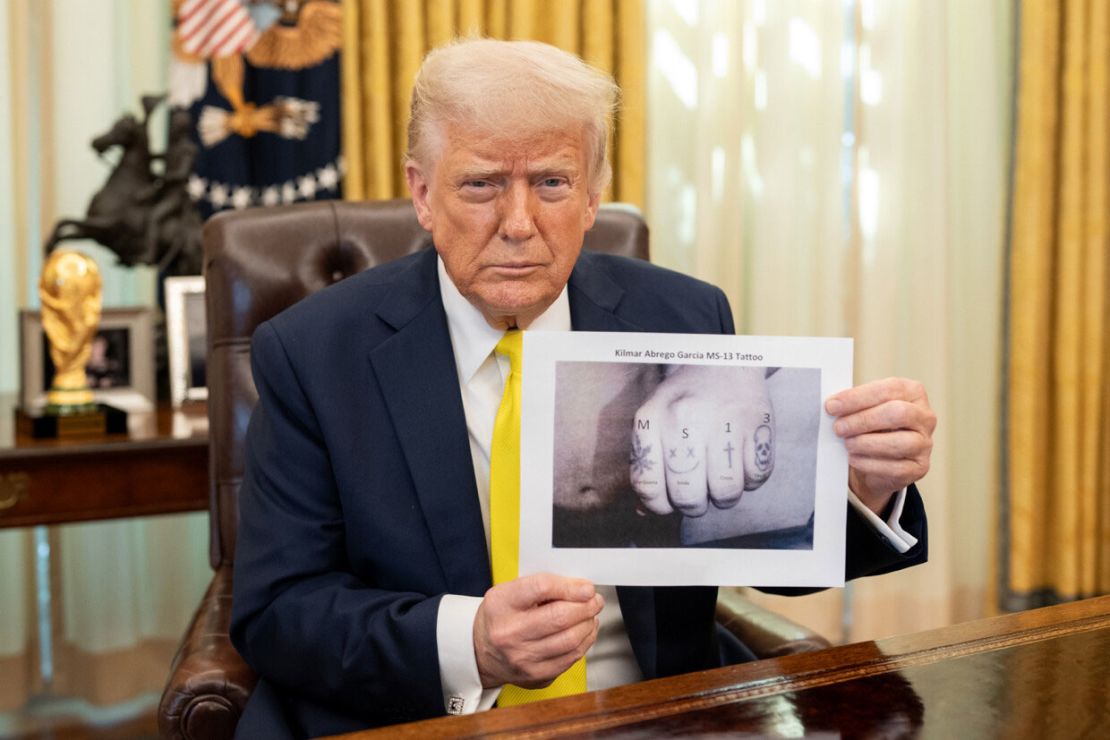 In this photo posted to Truth Social made on April 21, President Donald Trump poses with what appears to be a digitally altered image of Kilmar Abrego Garcia’s knuckles, where the letters “MS-13” have been added above Garcia’s existing tattoos.