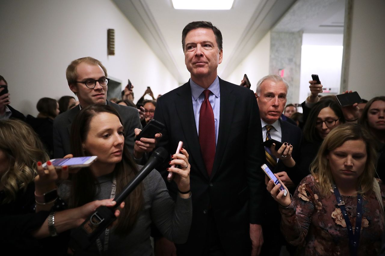 Former Federal Bureau of Investigation Director James Comey is surrounded by reporters after testifying to the House Judiciary and Oversight and Government Reform committees on December 07, 2018