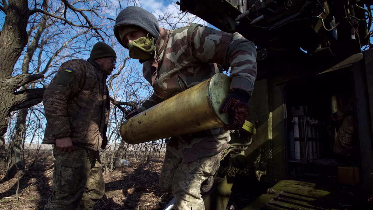 A Ukrainian serviceman carries a shell for a self-propelled howitzer before firing it toward Russian troops outside of Bakhmut, Ukraine, on Sunday.