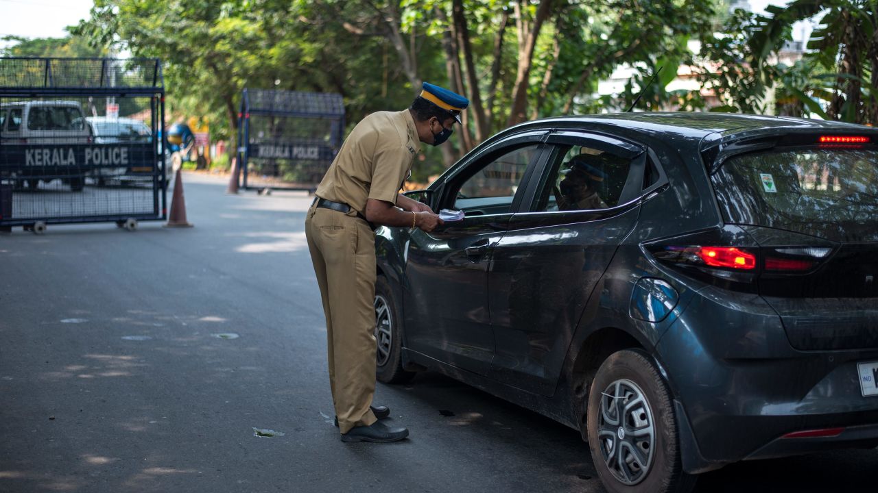 A policeman speaks with commuters during weekend restrictions imposed to curb of coronavirus in Kochi, India, on Sunday, April 25. 