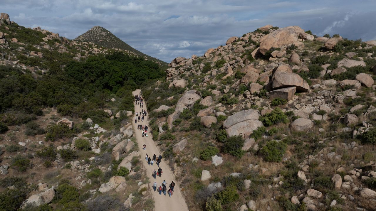 A drone view shows asylum seeking migrants from China and Turkey as they climb a hill while looking to surrender to immigration officials after crossing the border into the United States from Mexico in Jacumba Hot Springs, California, on May 20. 