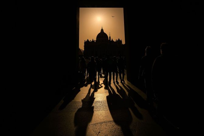 People walk around St. Peter's Square in the Vatican on Tuesday, April 22.
