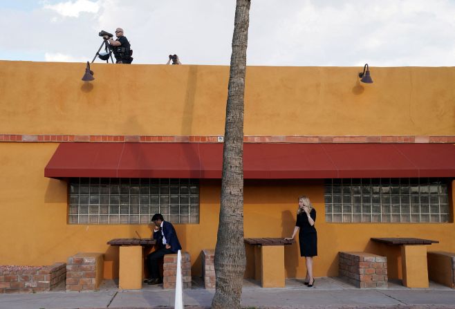 Vinay Reddy, Biden's director of speechwriting, works at his laptop while White House economic advisor Lael Brainard talks on her phone outside a Mexican restaurant in Phoenix where Biden was holding a campaign event on March 19.