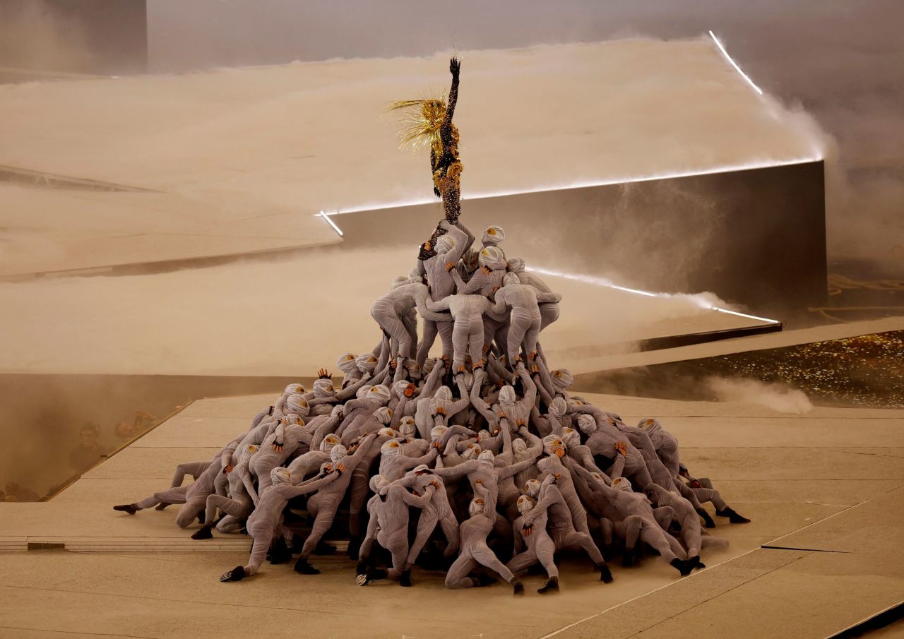 A Golden Voyager, inspired by references from French history, stands atop a pile of masked dancers as the last Olympic ring is raised above the stage. 