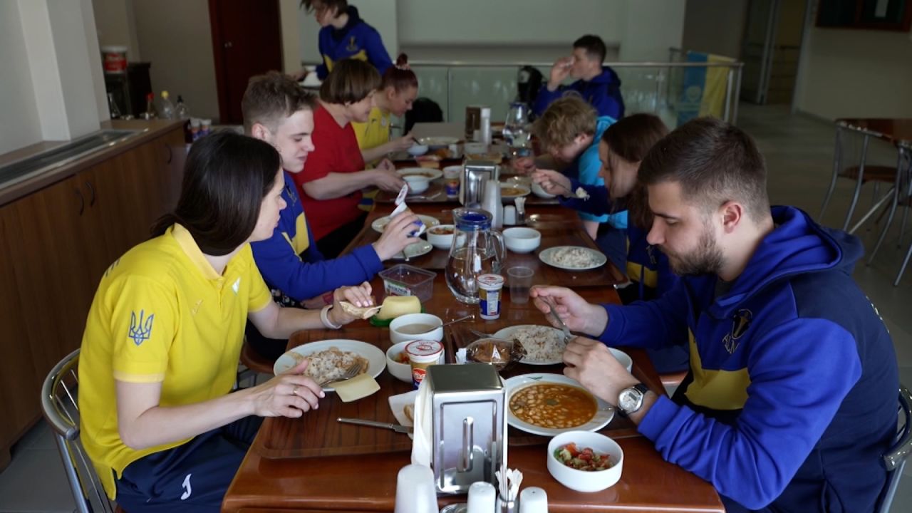 The Ukrainian swim team sits down to eat a meal together at Kas?mpa?a SK football club.