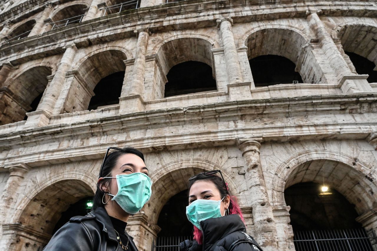 Tourists wear protective masks as they tour outside the Coliseum in Rome on January 31.