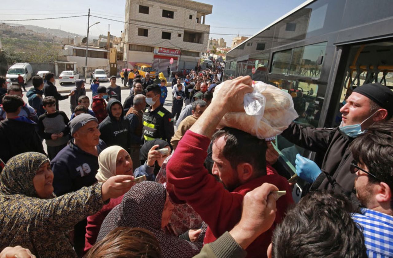 People queue to buy subsidized bread from a municipal bus in the Marka suburb in the east of Jordan's capital Amman on March 24. 